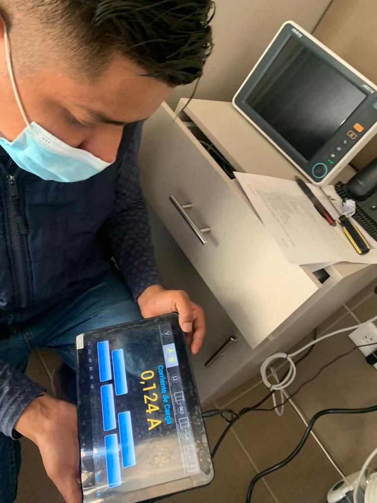 Técnico realizando medición de mantenimiento en equipo médico